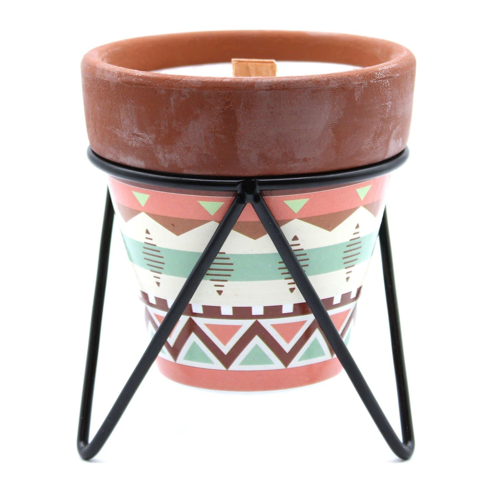 Herb garden soy candle in a rustic pot on a black metal stand
