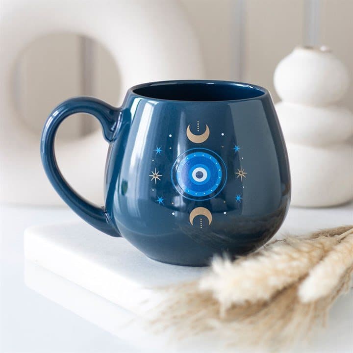 Dark blue rounded mug with all seeing eye, crescent moons and stars
