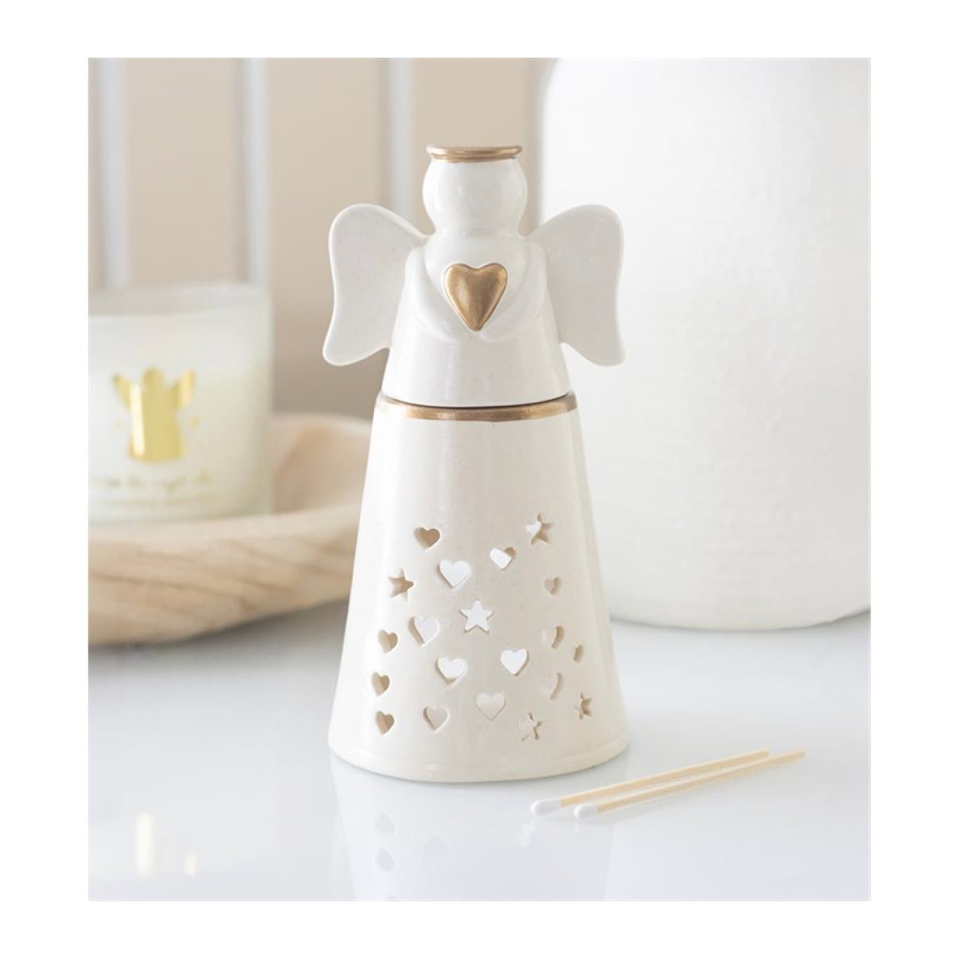 White ceramic angel-shaped oil burner with heart and star cut-outs