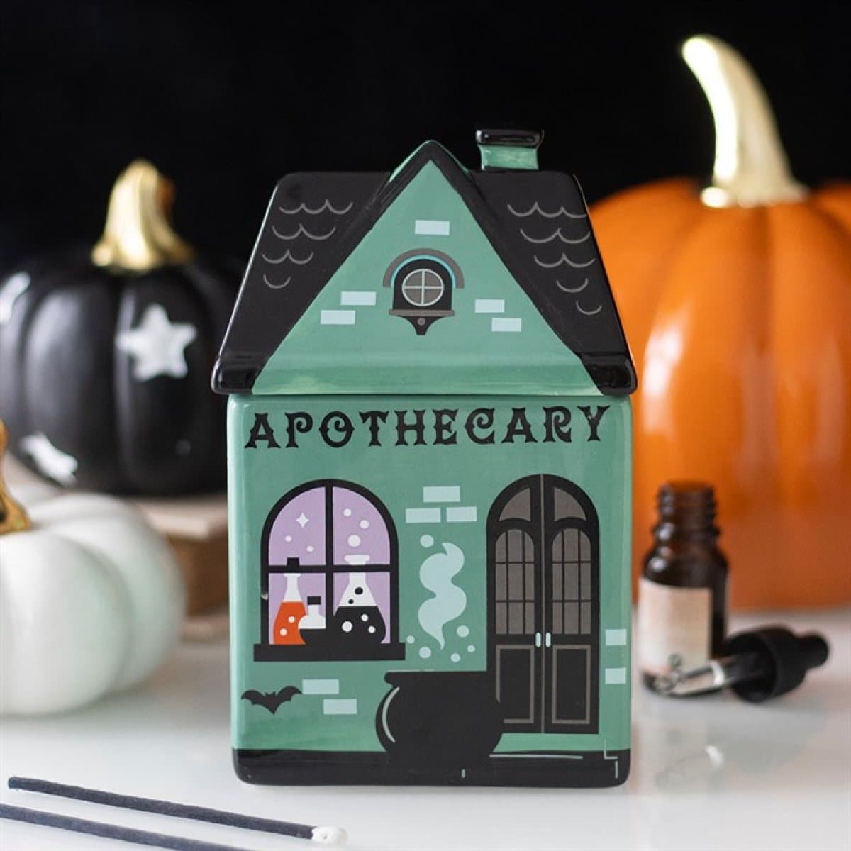 Ceramic oil burner shaped like an apothecary shop with a cauldron and potions