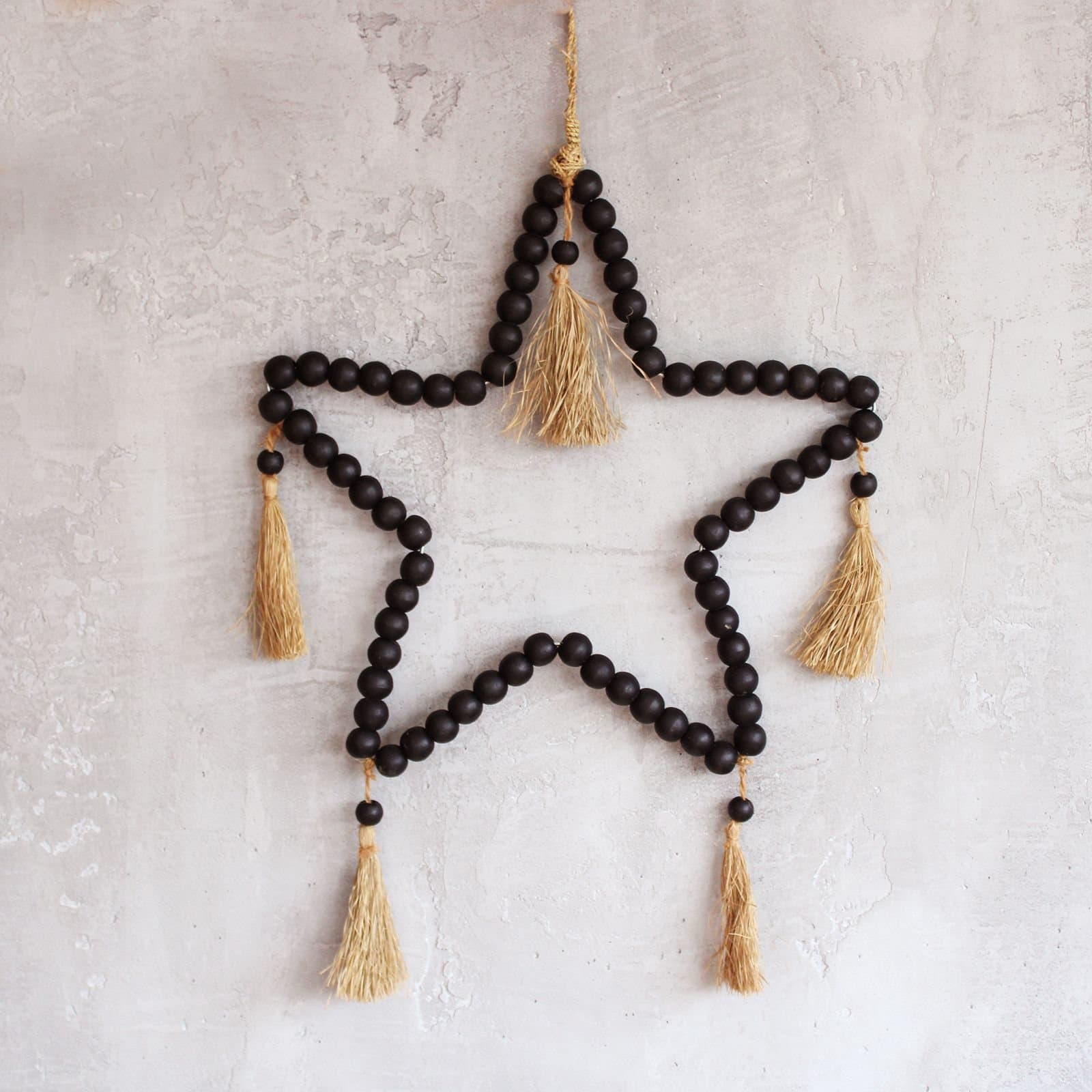 Large star-shaped mobile made with raffia and pinewood beads