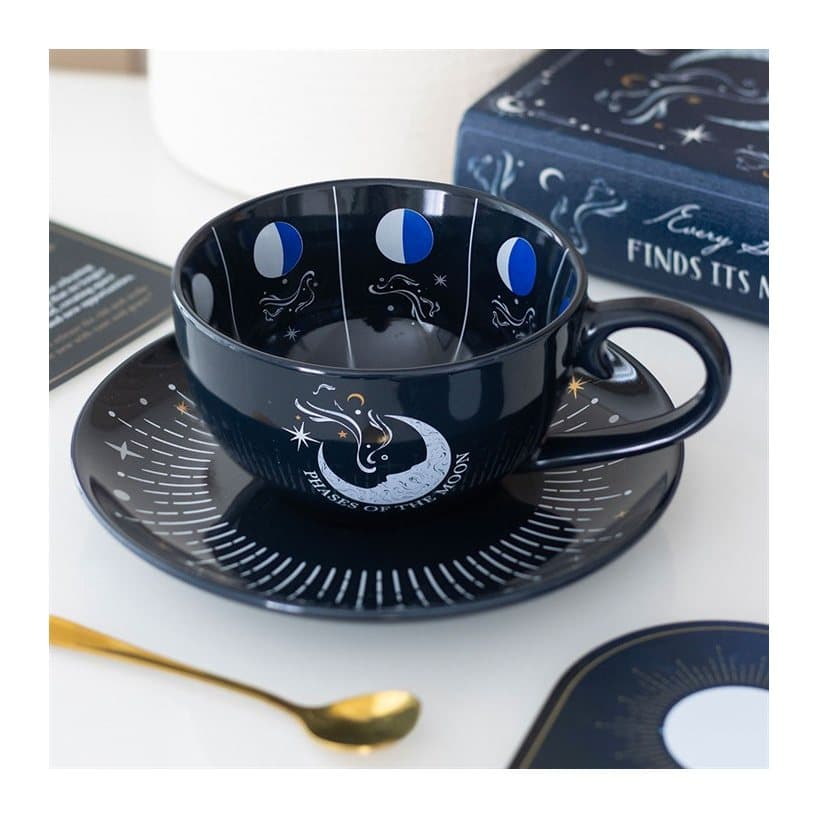 Blue ceramic teacup and saucer decorated with moon phases