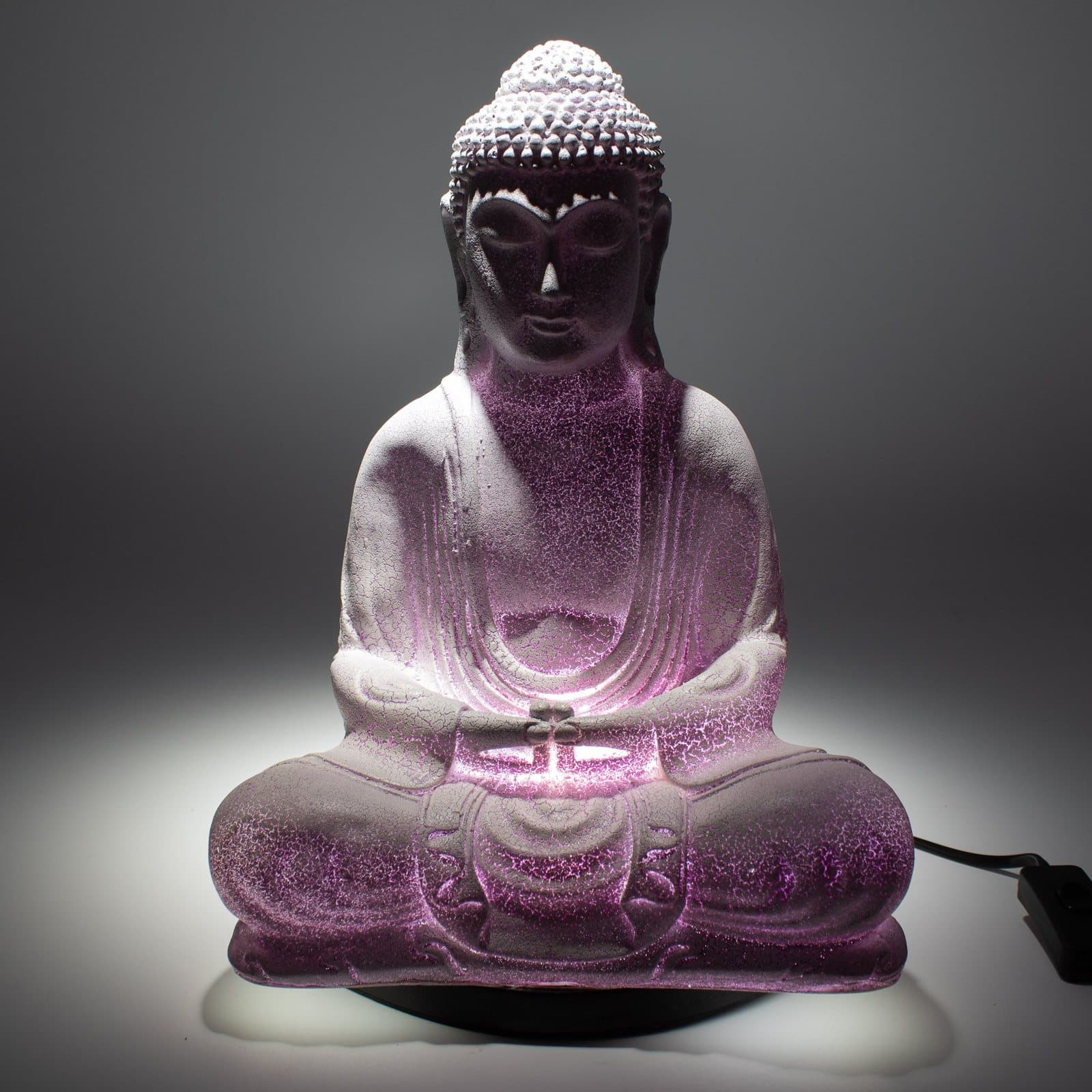 Glass Buddha lamp glowing on an oval stand