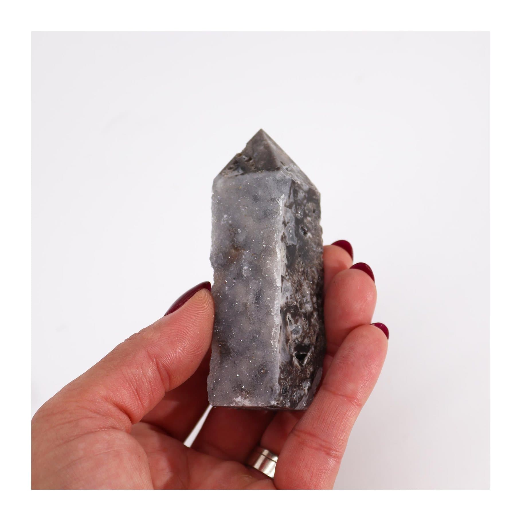 A calcite crystal tower with rough natural surfaces and smooth polished areas