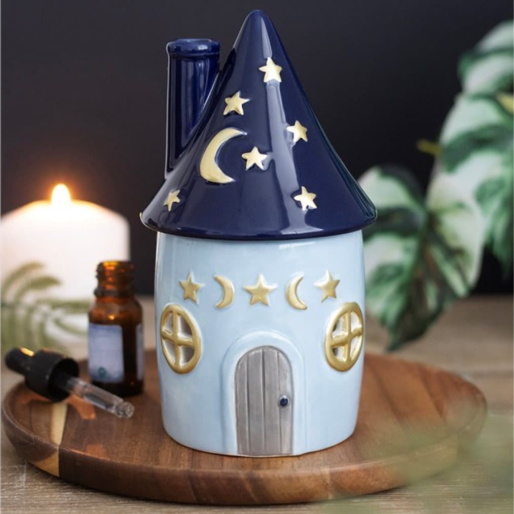 Ceramic cottage oil burner with a pointed starry roof and crescent moons
