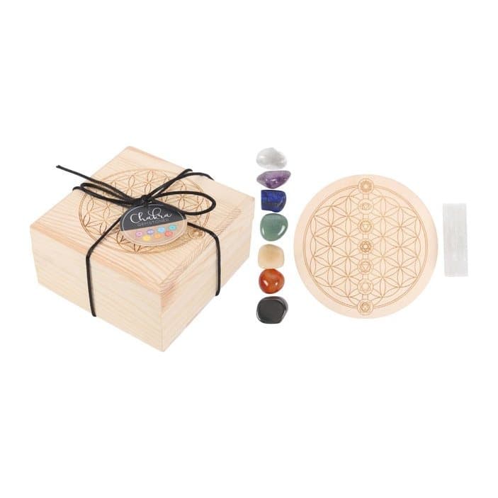 Seven chakra tumbled stones, a selenite wand and a Flower of Life grid in a wooden box