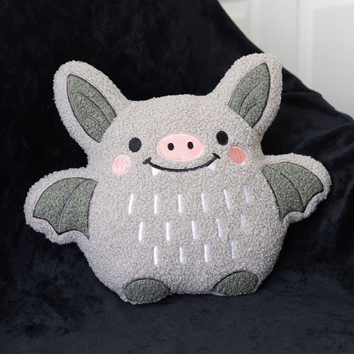 Boucle cushion shaped like a happy little bat