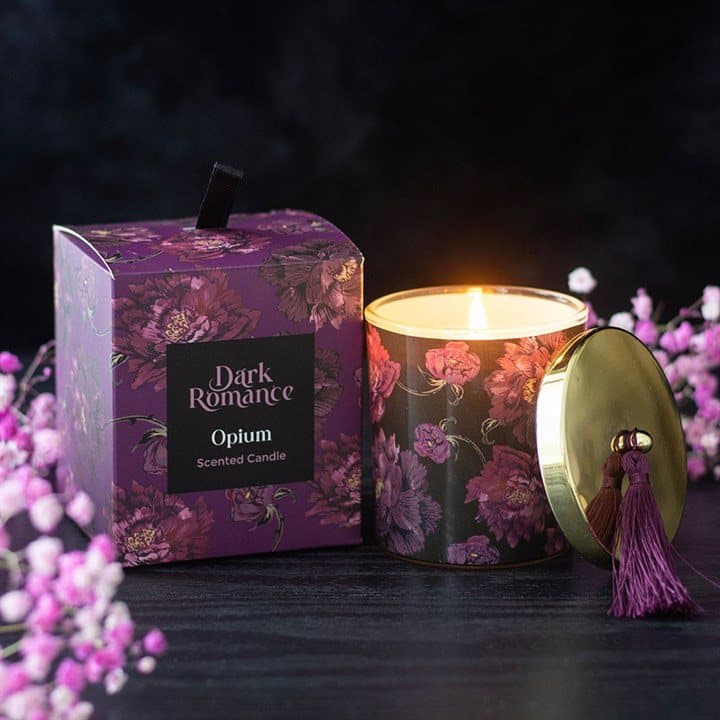 Lidded glass opium scented candle wrapped with purple blooms and topped with a tassel