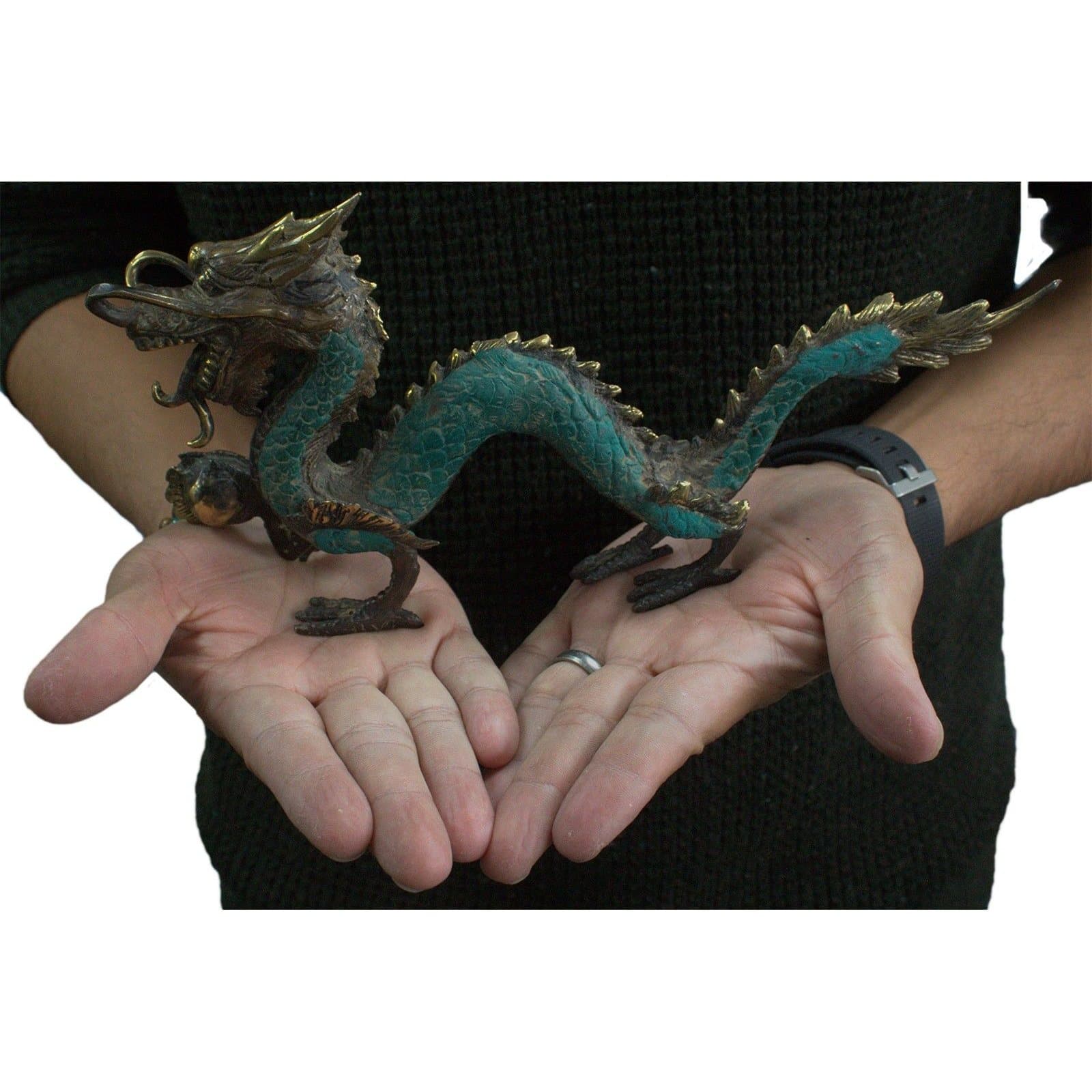 Brass feng shui dragon figure with a ball