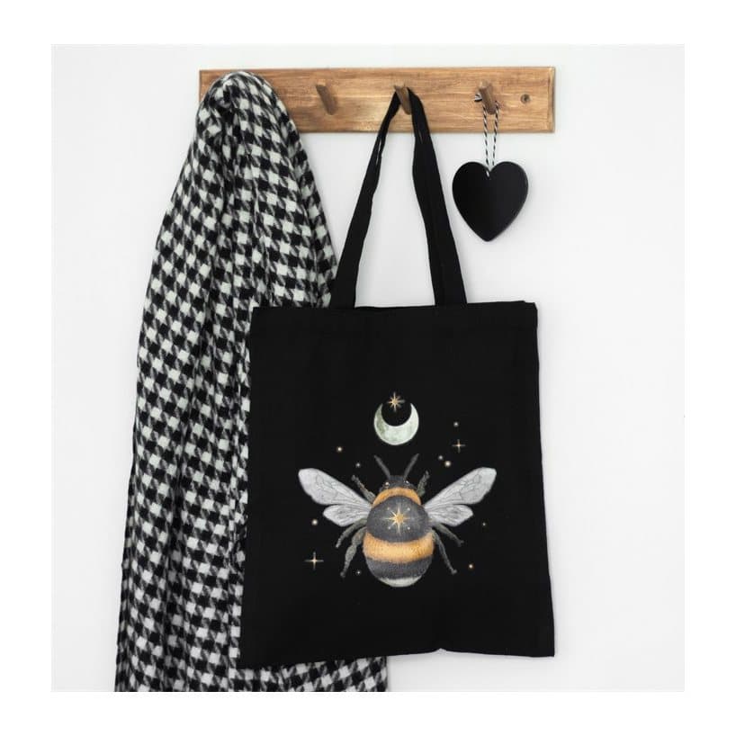 Black canvas tote bag with a delicate forest bee design