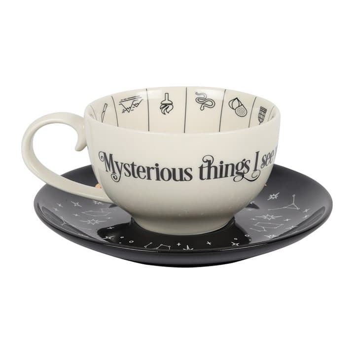 Fortune telling teacup with gold foil symbols on a black saucer