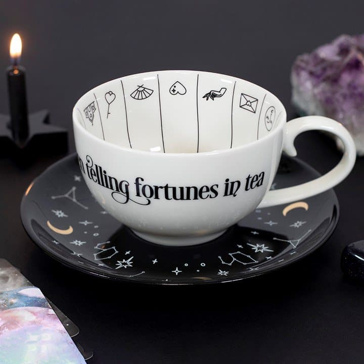 Fortune telling teacup with gold foil symbols on a black saucer