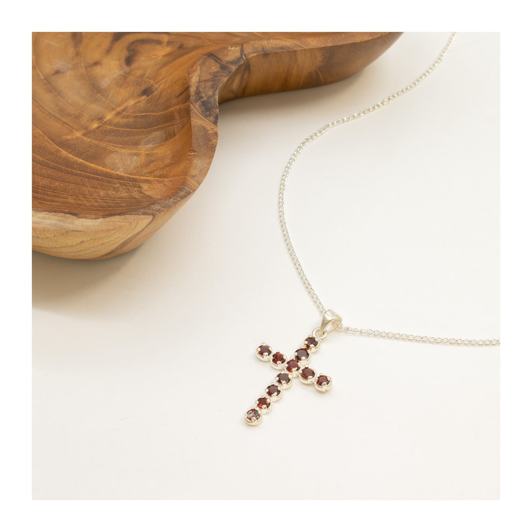 Silver-plated crucifix pendant with deep red stones on a slim chain