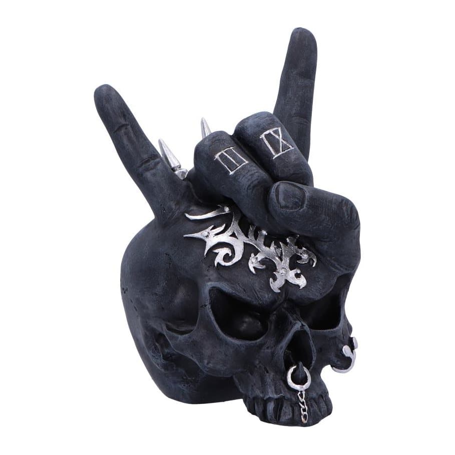 Black resin skull ornament with silver piercings and a tattooed devil horns hand