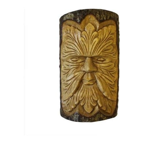 Carved wooden Green Man face on a tree trunk offcut