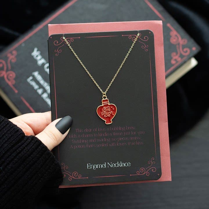 Enamel love potion charm necklace on a matching greeting card