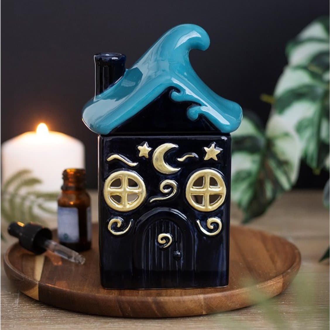 Blue ceramic cottage oil burner with golden moons and a wave-shaped roof