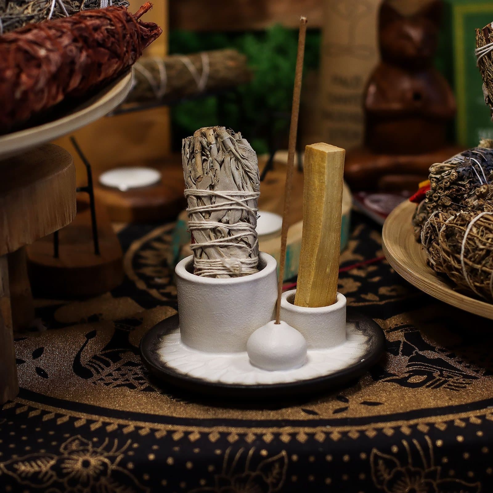Round ceramic holder with places for a sage bundle, a palo santo stick and incense