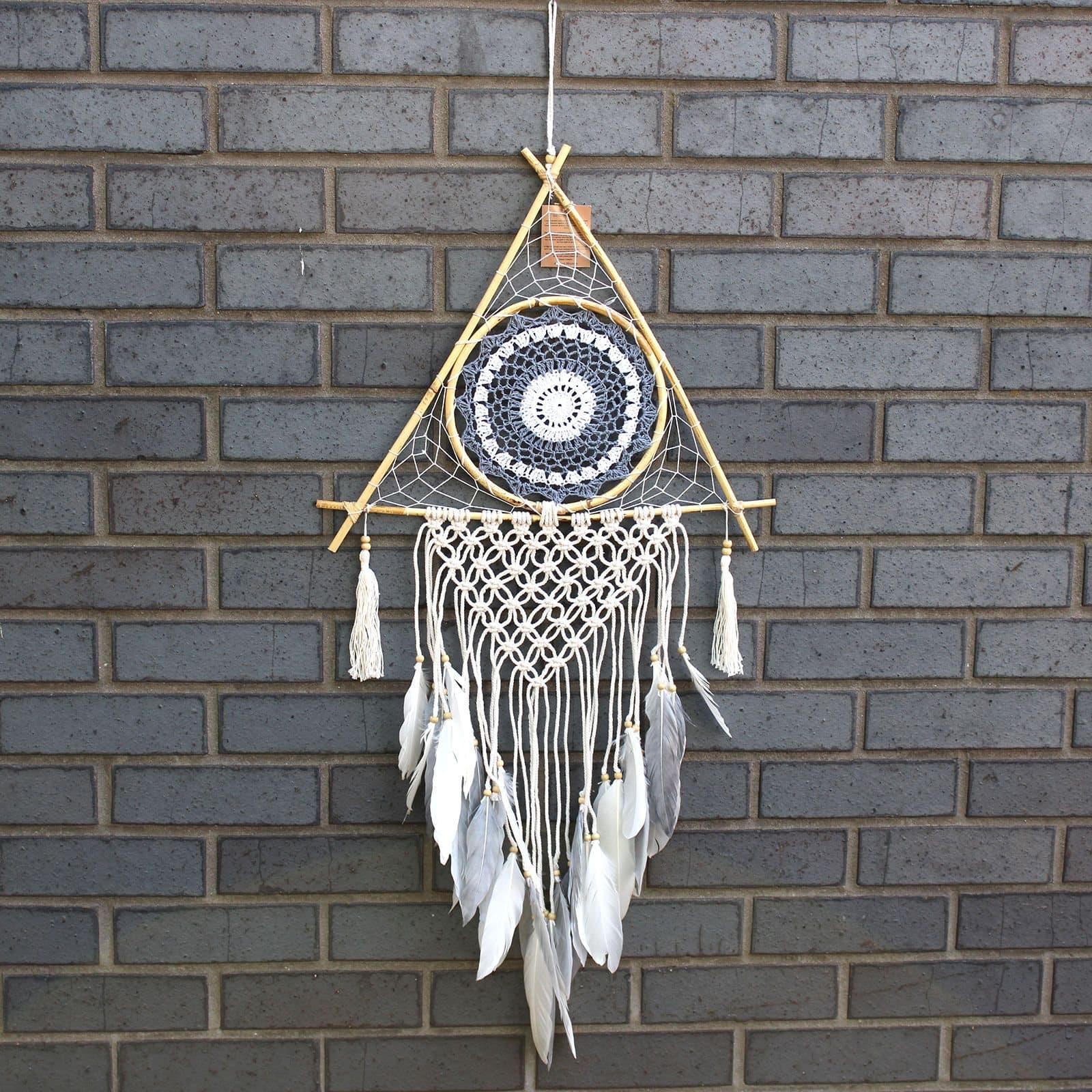 White and grey macrame pyramid dreamcatcher with an evil eye and feathers