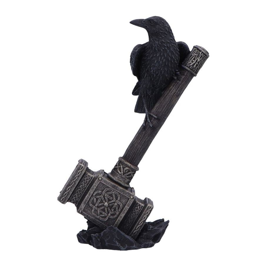 Black raven perched on Thor's hammer with a golden head on black rocks