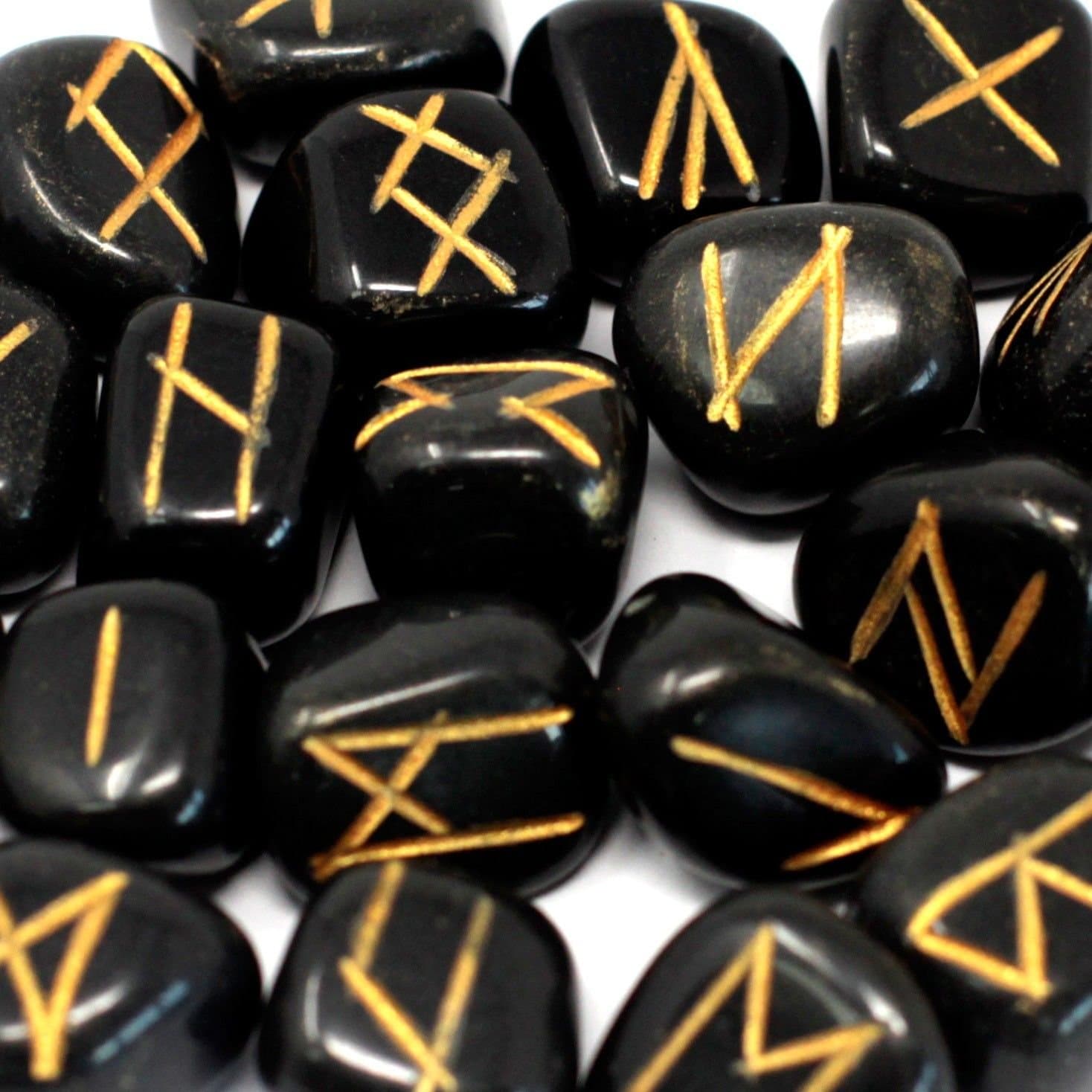 Agate rune stones marked with rune symbols beside a cotton printed pouch