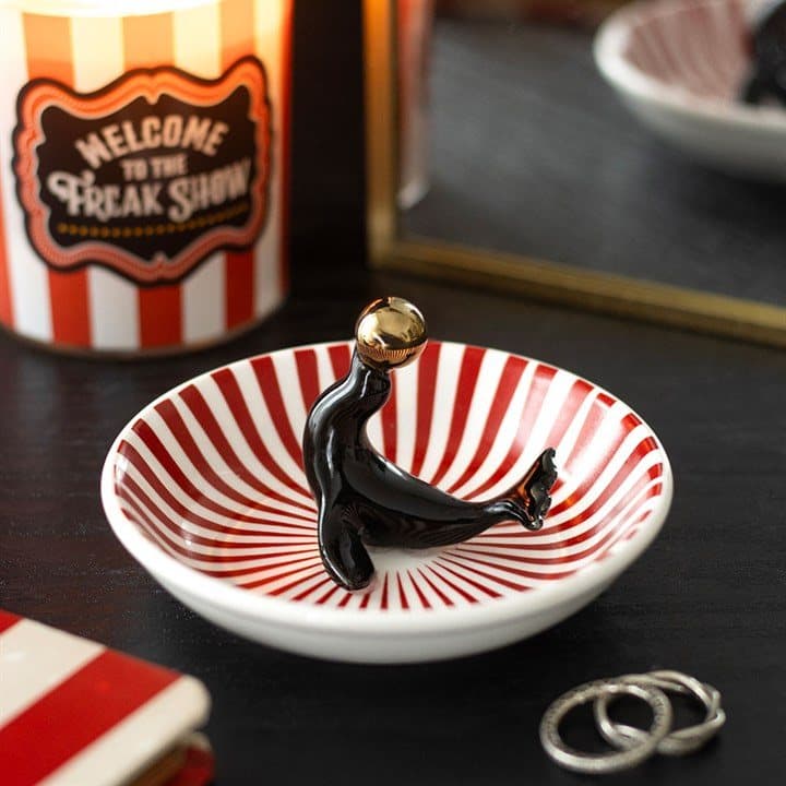 Ceramic trinket dish with a black circus seal and golden ball on red and white stripes