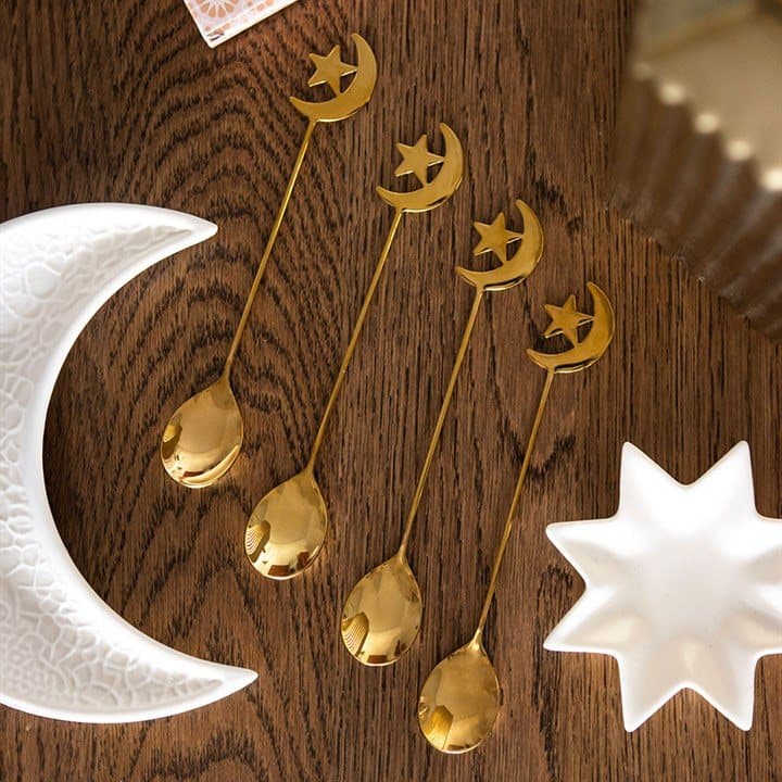 Four golden teaspoons with moon and star cut-out handles