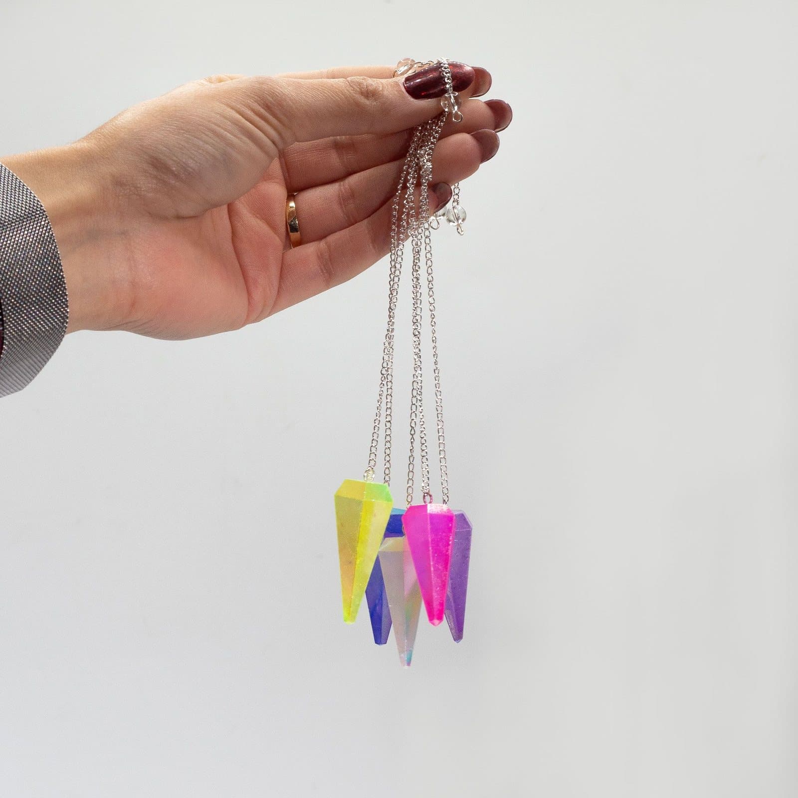 Six-sided aurora crystal pendulum on a chain with a small bead