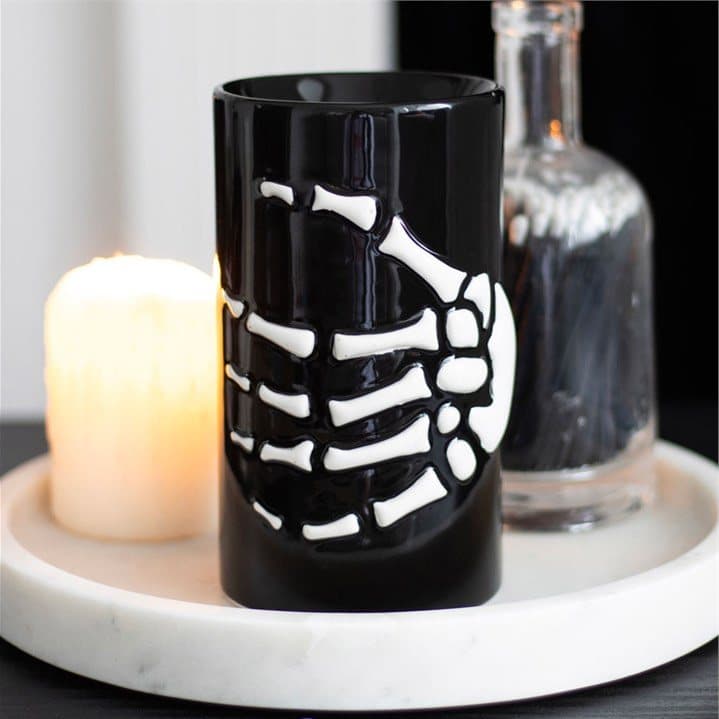 Resin oil burner with a skeleton hand wrapped around a black base