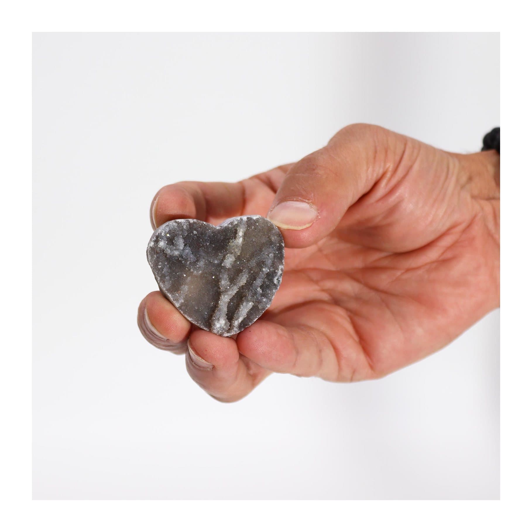 Heart carved from natural calcite showing banding and crystal texture