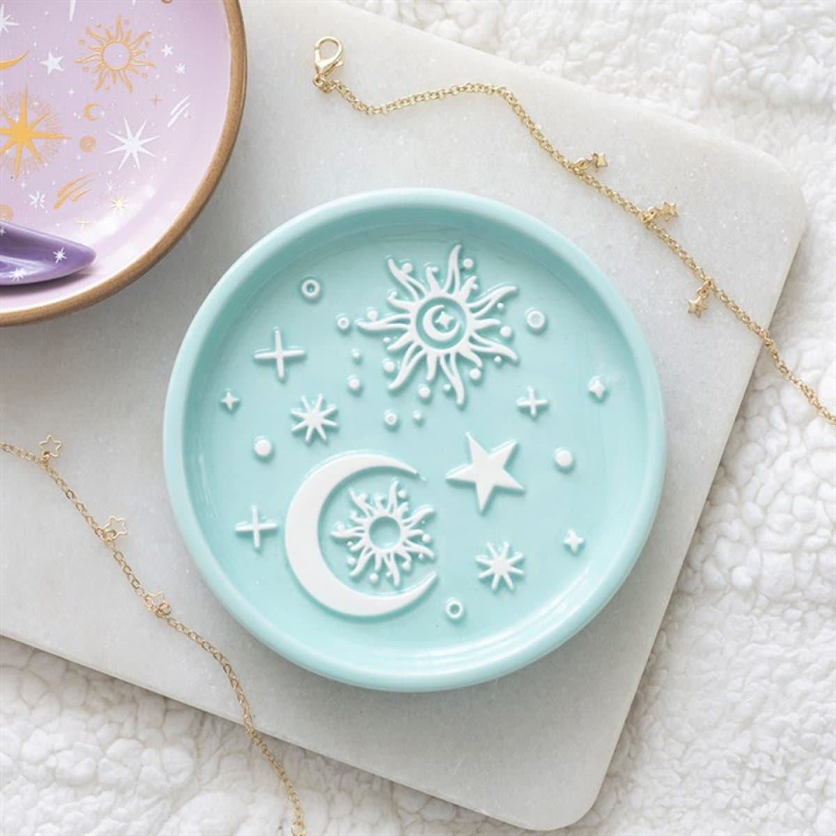 Pastel blue ceramic trinket dish with raised white moon, sun and star designs