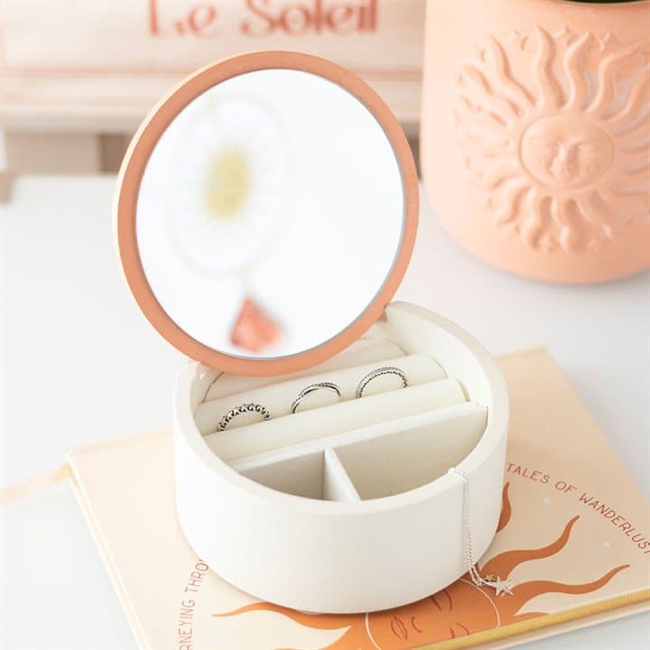 White jewellery box with a sun design and a mirror in the lid