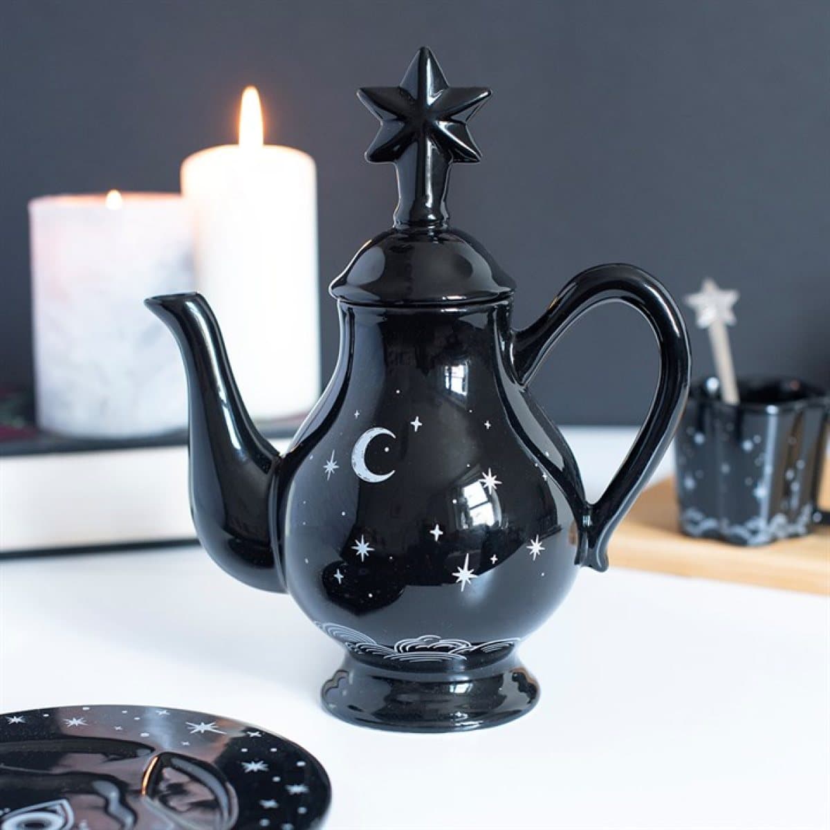 Black ceramic teapot with moon and star details and a star-shaped lid