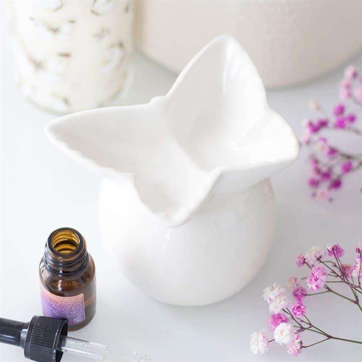 White ceramic oil burner with a butterfly-shaped bowl topper