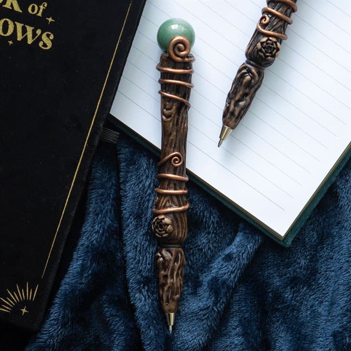 Magic wand pen tipped with a green aventurine crystal beside its moon phase box