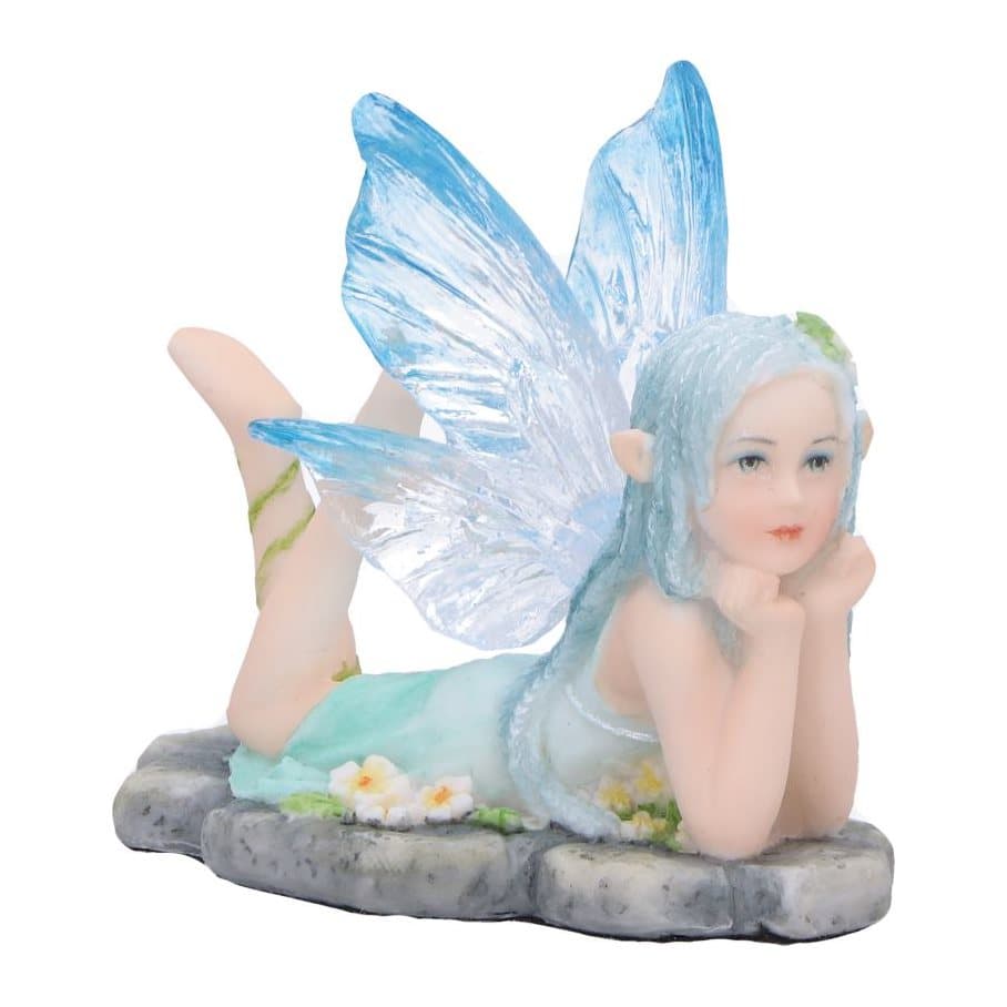 Ice fairy figurine with clear blue wings resting on a rock among flowers