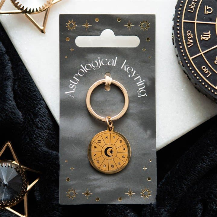 Gold tone astrology wheel keyring with zodiac symbols on a backing card