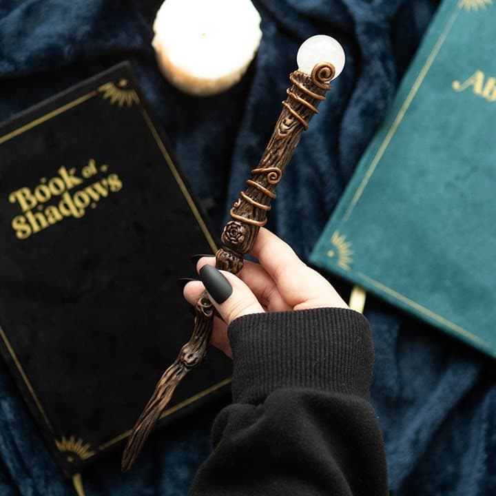 Resin magic wand with an aura quartz crystal beside its storage pouch