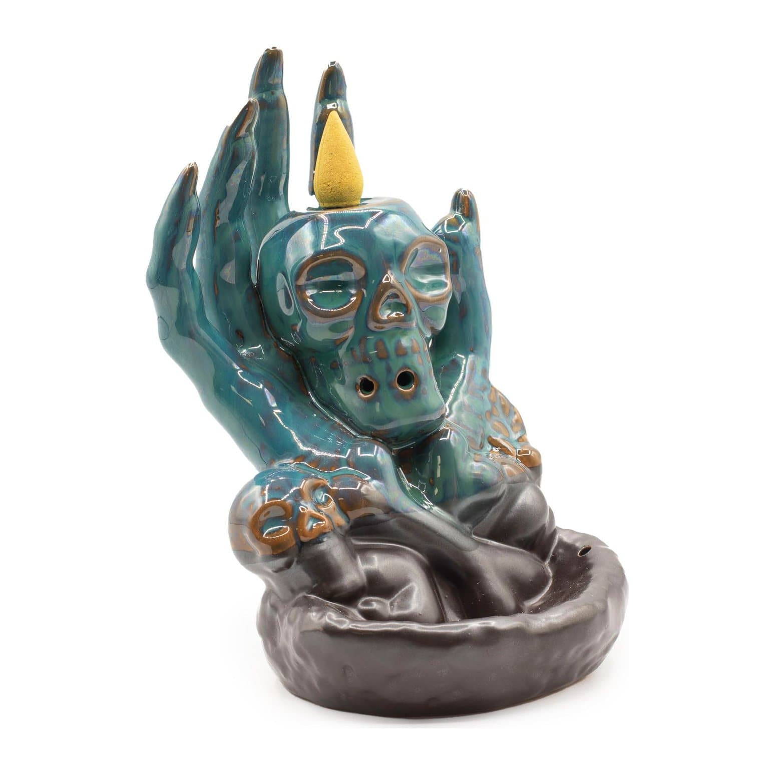 Blue-green ceramic backflow burner with a skull held in a hand