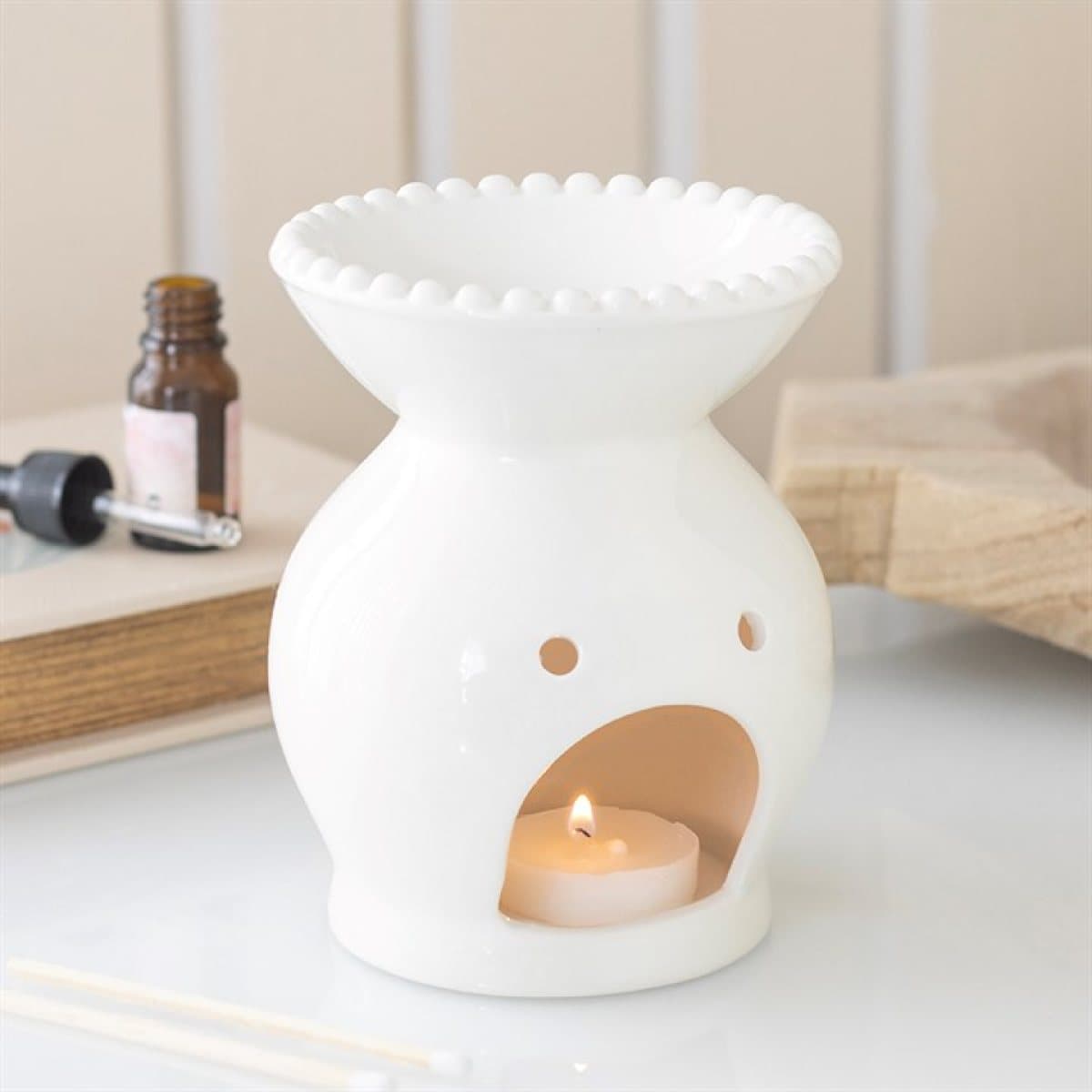 Ceramic oil burner finished with a decorative beaded rim