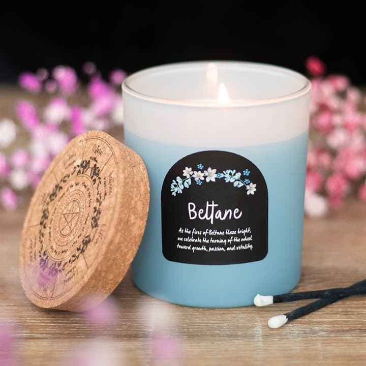 Beltane orange blossom candle in a glass jar with a cork lid