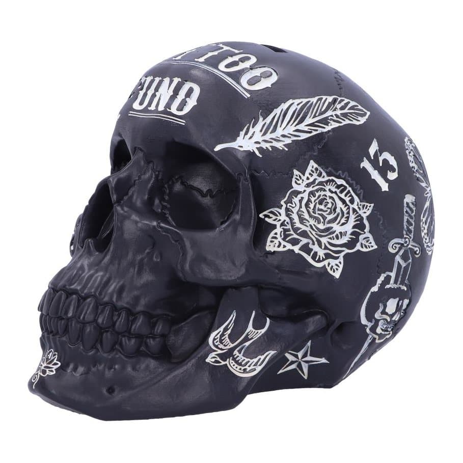 Black skull money box covered in white tattoo-style designs
