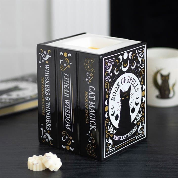 Ceramic oil burner shaped like three stacked spell books with black cat details