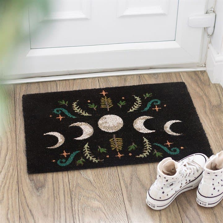 Black coir doormat with a moon phase design and magical plants