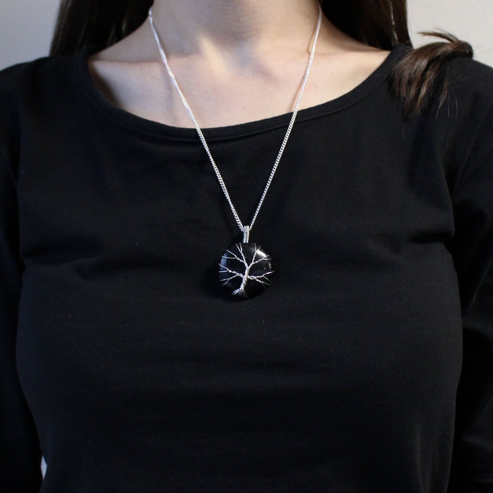 Black onyx gemstone in a Tree of Life cage on a necklace chain