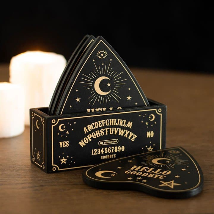 Four black and gold planchette-shaped coasters with a matching holder
