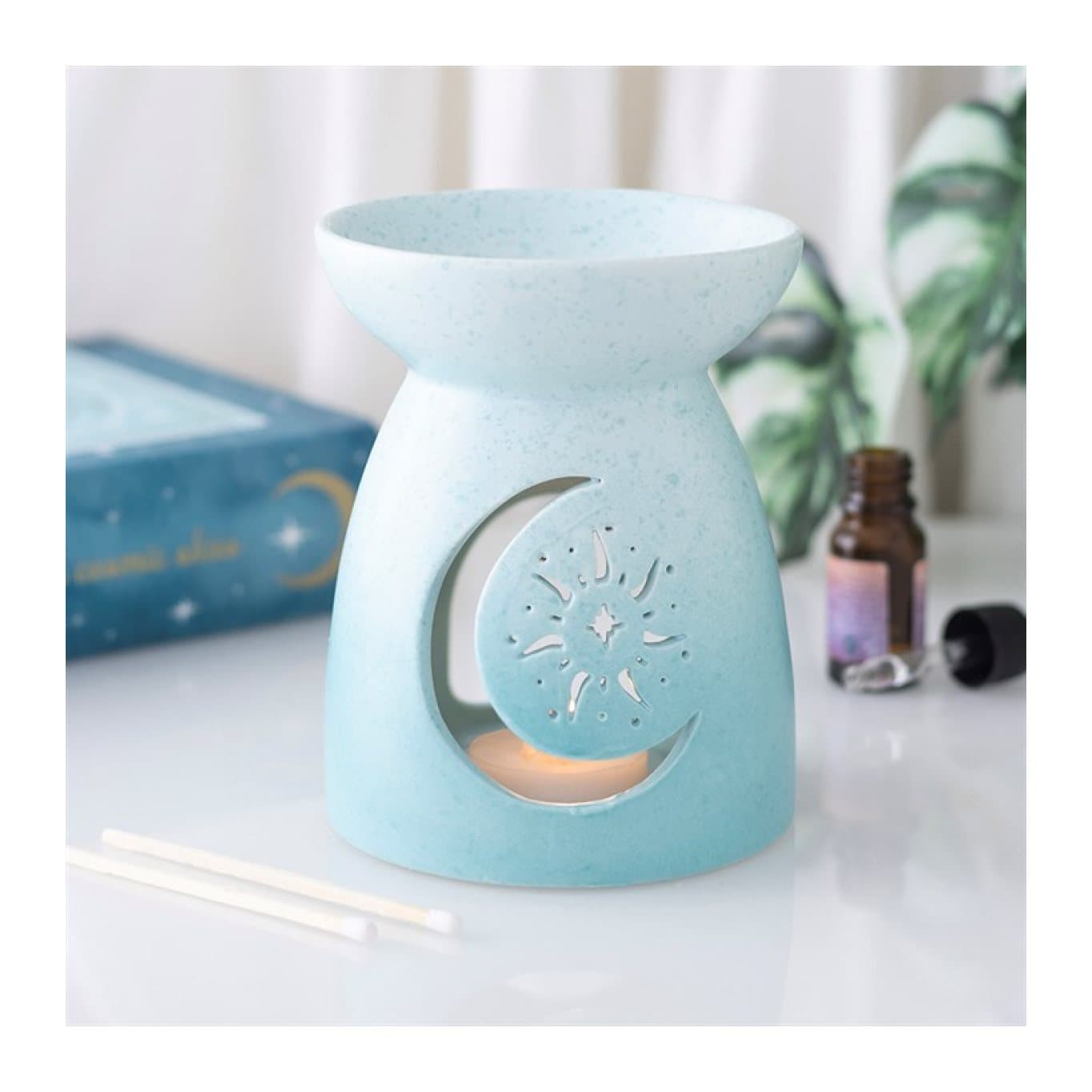 Pastel blue ceramic oil burner with a decorative moon cut-out