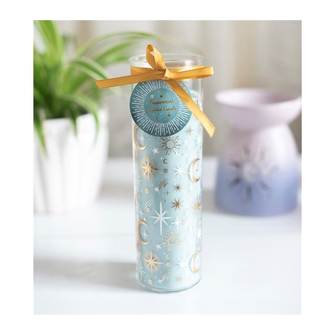 Blue tube candle in glass with a celestial design and hang tag