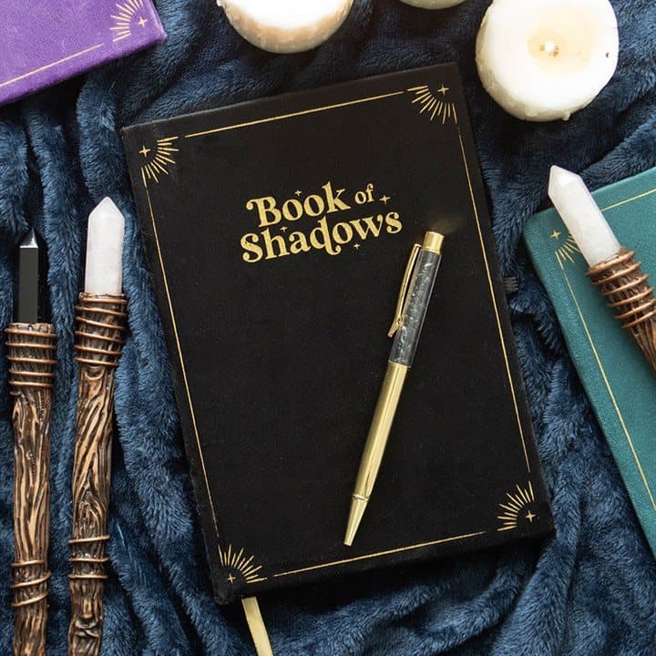 Black Book of Shadows journal with gold detailing and black obsidian crystal pen