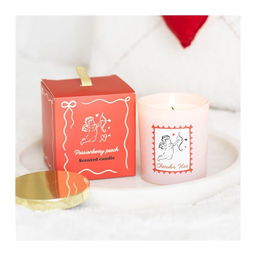 Blush pink glass jar candle with gold lid and cupid-themed stamp label